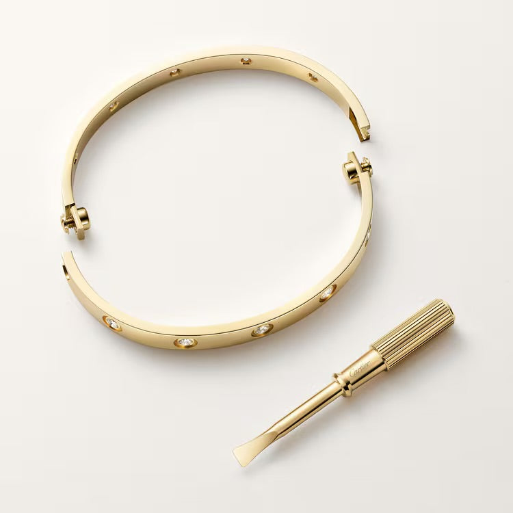 Love bangle in 18K gold plated finish with screw motifs, clear zirconia accents, and signature screwdriver